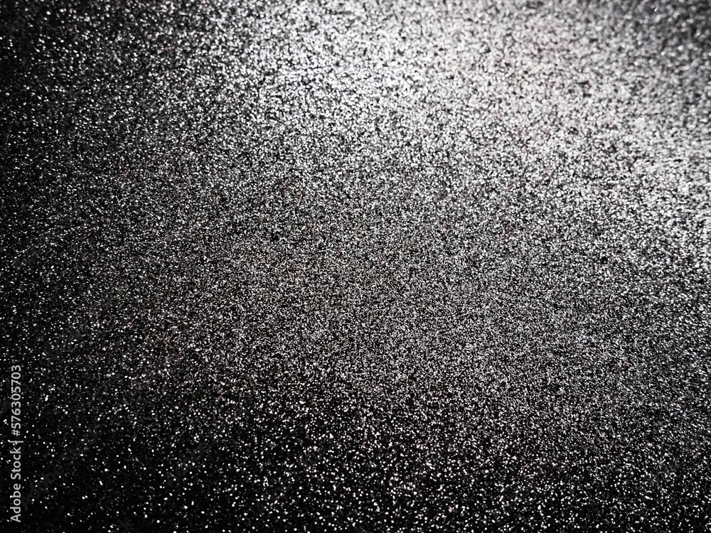 Black glitter texture christmas background. Bent shiny velvet paper