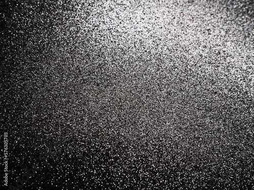 Black glitter texture christmas background. Bent shiny velvet paper