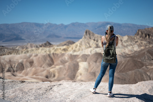 a young girl with her back turned to take pictures of the desert landscape in Death Valley Desert