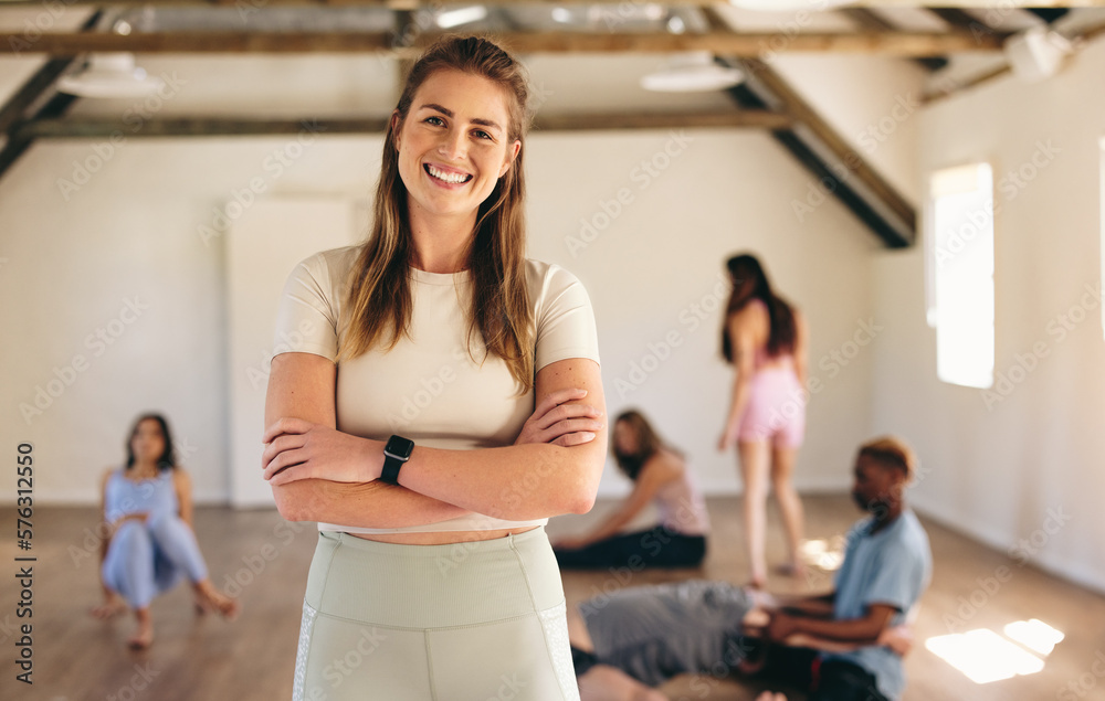 Female fitness instructor standing in a yoga class Female fitness instructor standing in a yoga class