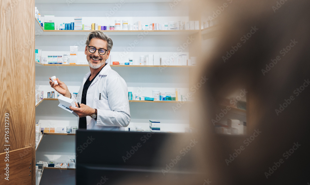 Pharmacist picking prescription medication from a shelf in a drug store