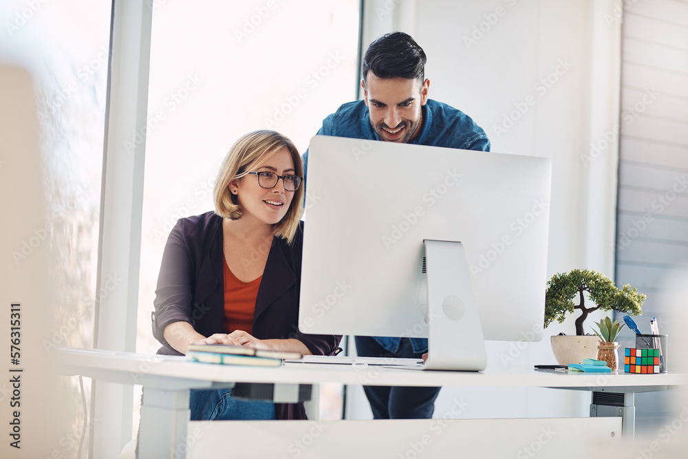 Putting technology to work. Shot of a young man and woman using a computer together in a modern office. Putting technology to work. Shot of a young man and woman using a computer together in a modern office.