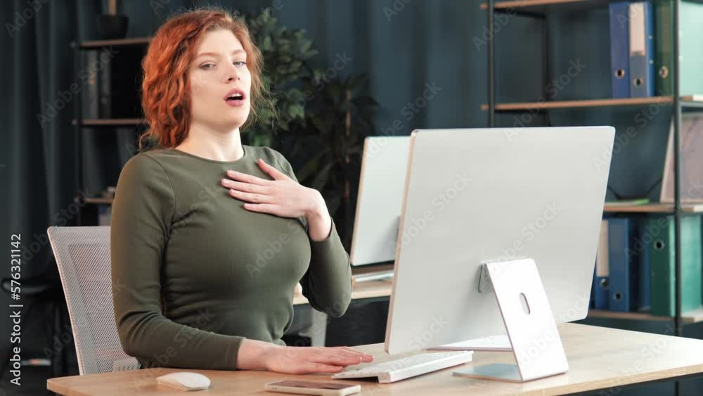 Beautiful sick female office worker having panic attack at workplace. Woman employee having shortness of breath, tired suffering from severe chest pain heartache at work indoor. Breathing problems.