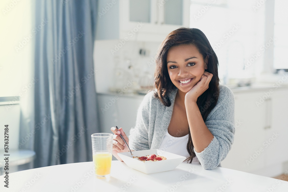 Glowing with health and happiness. Portrait of a happy young woman enjoying a healthy breakfast at home. Glowing with health and happiness. Portrait of a happy young woman enjoying a healthy breakfast at home.