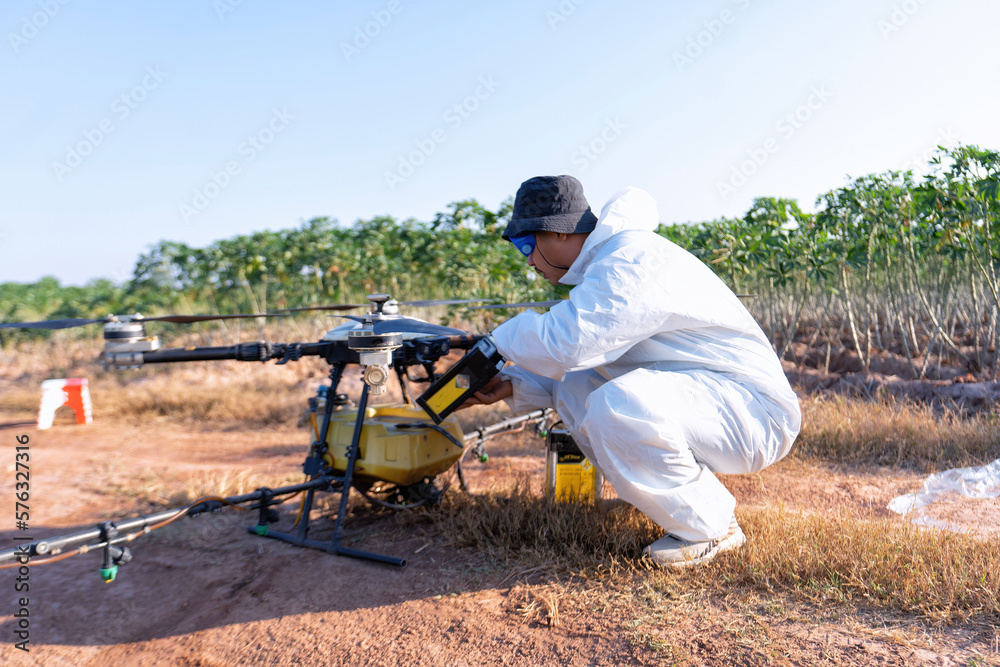 Farmer stop fly drone at ground to replace empty battery at the rice field hi technology agriculture