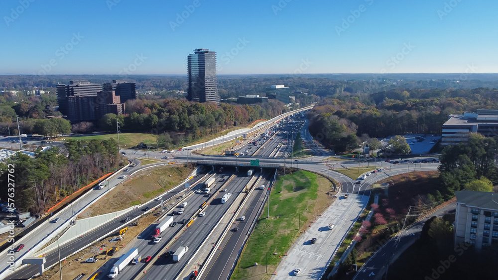 Busy traffic on Highway I-285 (the Perimeter) with construction sites, midtown Atlanta buildings mixed-use developments in urbanizing Dunwoody, Georgia, USA