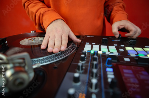 Hip hop dj scratching vinyl record on turntable player. Close up photo of disc jockey playing music on party. Disk jokey scratches disc with music on deck