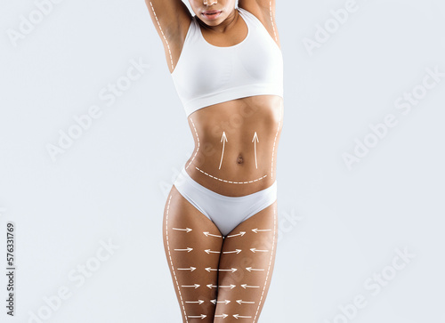 Millennial slim african american female in lingerie enjoy weight loss result with abstract lines on body photo