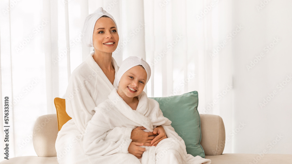 Spa Day. Beautiful Mom And Little Daughter Wearing Bathrobes Relaxing On Couch Spa Day. Beautiful Mom And Little Daughter Wearing Bathrobes Relaxing On Couch