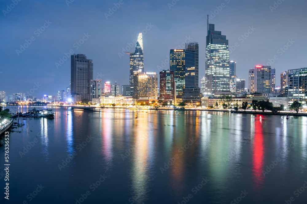 Night cityscape of Ho Chi Minh City with illuminated street light reflected on the river, formerly known as Saigon, is the largest city in Vietnam and one of popular destinations in South East Asia.
