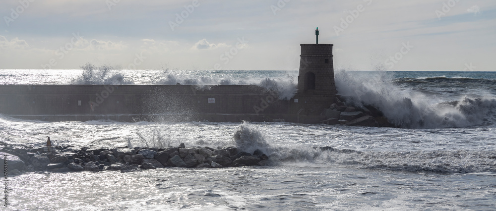 Rough sea on the pier of Recco with the lighthouse, Genoa province, Italy.