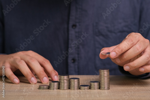 Businessman hand holding money on the desk. Saving money, income, earning and investment concept. © Bordinthorn