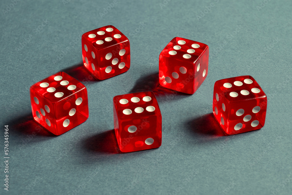Random number generator. Five red dice with numerical values lie in a chaotic order.