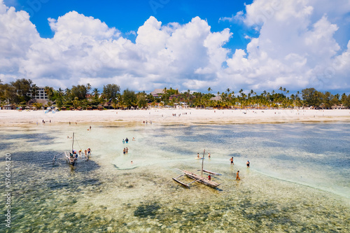 The stunning beauty of Kiwengwa beach in Zanzibar is on full display in this mesmerizing aerial drone footage, showcasing its palm tree-lined shore and turquoise waters photo