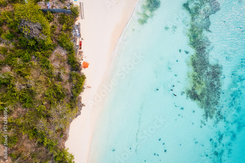 The aerial view of Zanzibar's Indian Ocean coastline is simply stunning, featuring palm trees, white sand, and sparkling blue waters. With luxurious hotels and a tropical landscape, it is the perfect 
