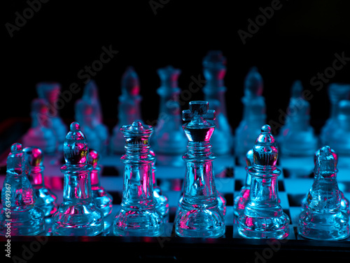 glass chessboard in blue and pink color with black background photo