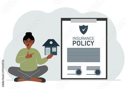 A woman holds in his hands at home next to a large insurance contract. Home and real estate insurance concept.