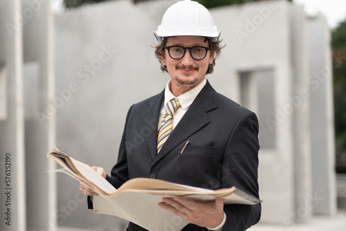 Portrait caucasian engineer man in suit holding paper work at precast site work 