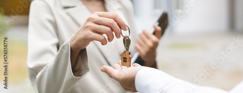 Close up view realtor broker holding home keychain in her hand.