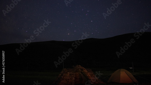 tents stand at night against the background of beautiful stars