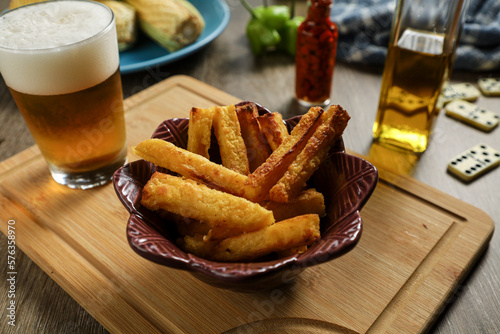 fried polenta in a brown bowl served with craft beer with pepper corn and olive oil background