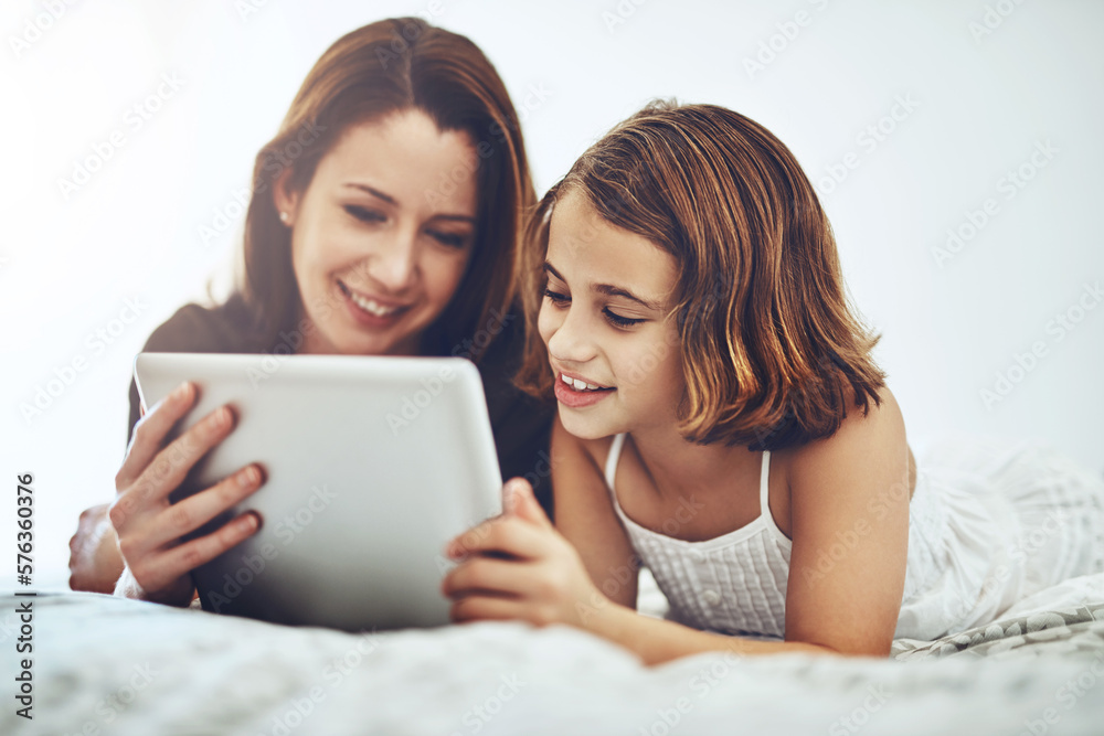 We have entertainment to last us all day long. Shot of a little girl and her mother using a digital tablet together. We have entertainment to last us all day long. Shot of a little girl and her mother using a digital tablet together.