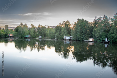 Paysage avec lac et maisons en bois de pêcheurs le soir