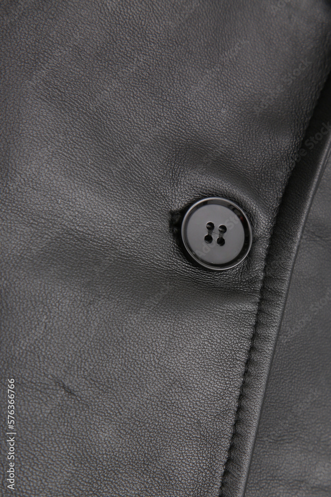 Detail of a black leather garment with an accessory in the form of a button or zipper Detail of a black leather garment with an accessory in the form of a button or zipper
