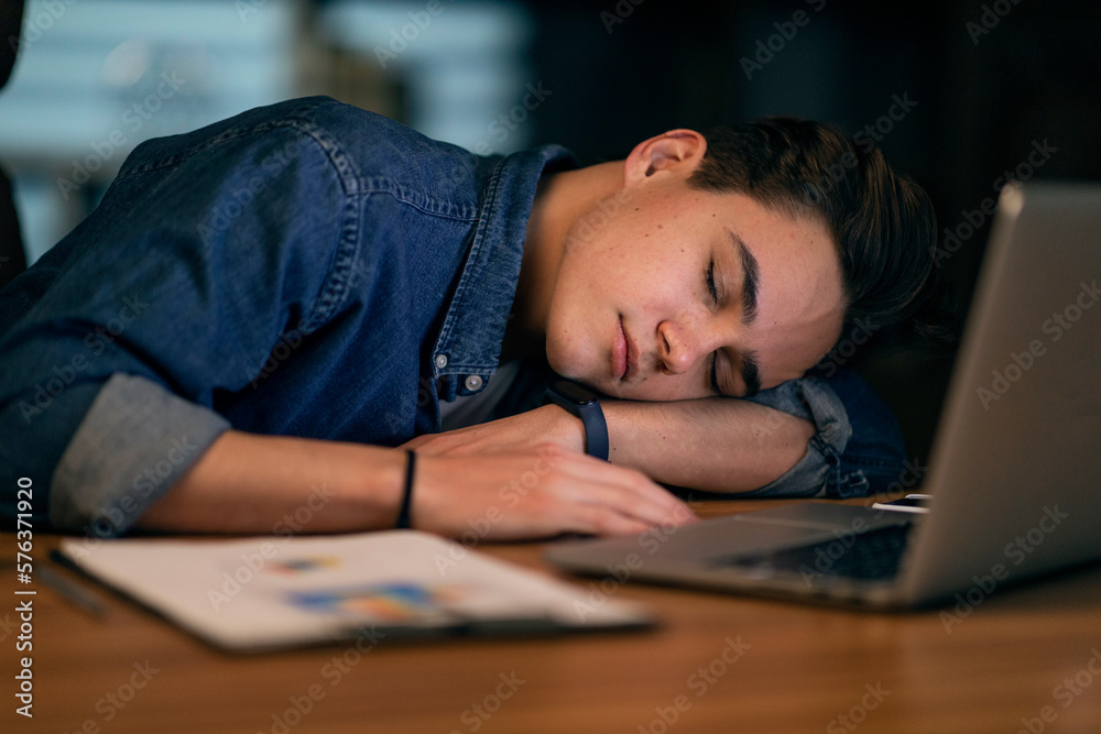 Closeup of young man manager sleeping at workdesk at office Closeup of young man manager sleeping at workdesk at office