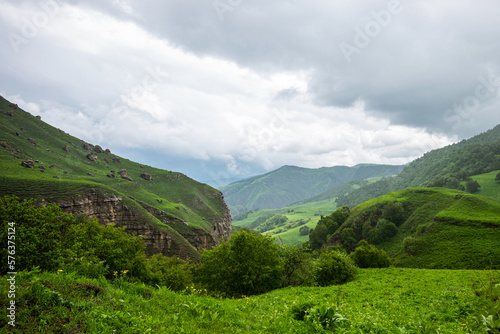 Wallpaper Mural Amazing view of green mountains with clouds and dramatic sky. Majestic mountains and a beautiful green valley surrounded by forested mountains on a rainy spring day. Torontodigital.ca