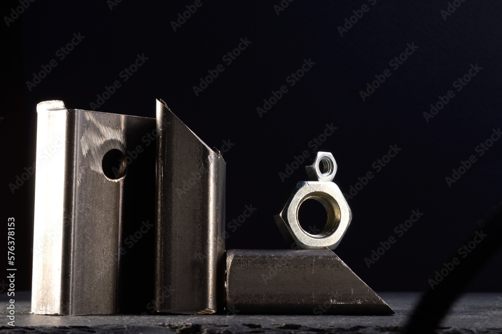 composition of nuts bolts and scraps of metal laid out on a dark background. composition of nuts bolts and scraps of metal laid out on a dark background.