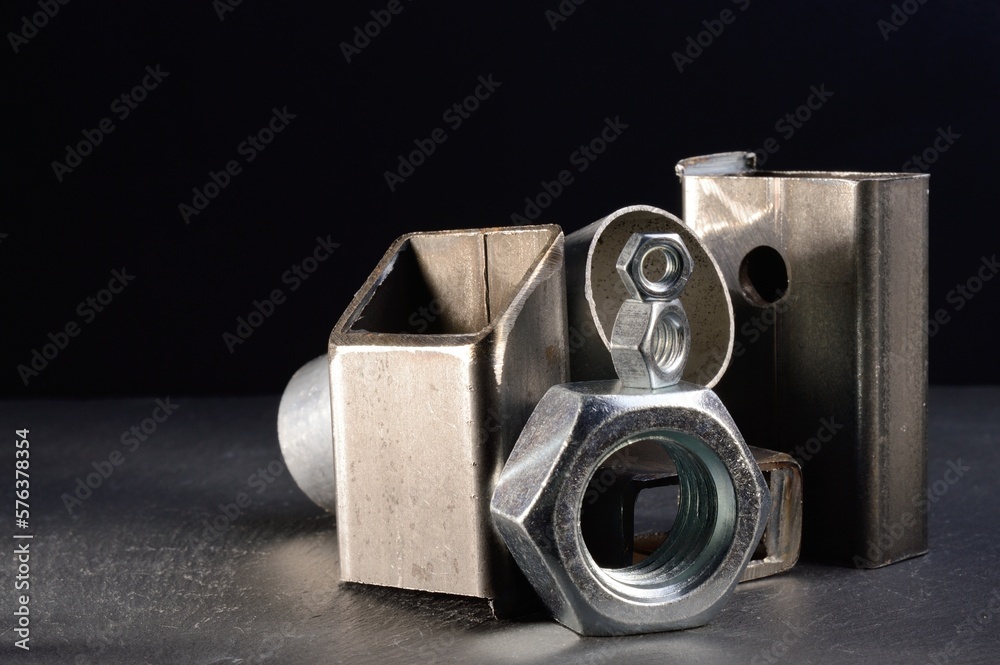 composition of nuts bolts and scraps of metal laid out on a dark background. composition of nuts bolts and scraps of metal laid out on a dark background.