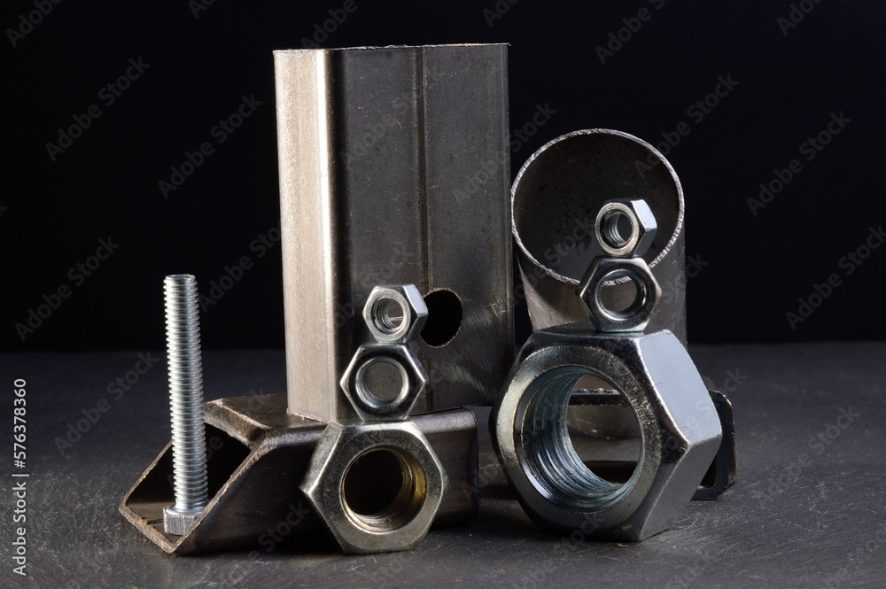 composition of nuts bolts and scraps of metal laid out on a dark background. composition of nuts bolts and scraps of metal laid out on a dark background.