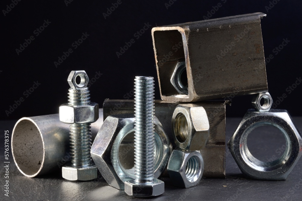 composition of nuts bolts and scraps of metal laid out on a dark background. composition of nuts bolts and scraps of metal laid out on a dark background.