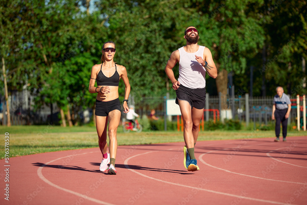 Obraz premium A team of track and field athletes, jointly a man and a woman, train while running.