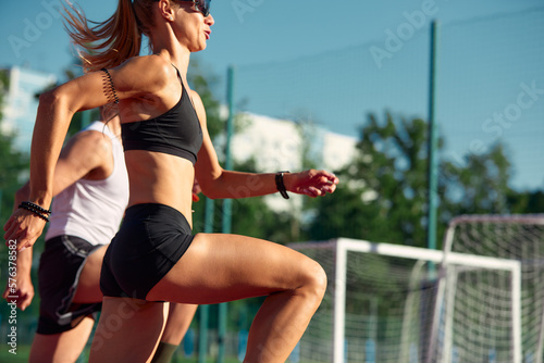 A team of track and field athletes, jointly a man and a woman, train while running.