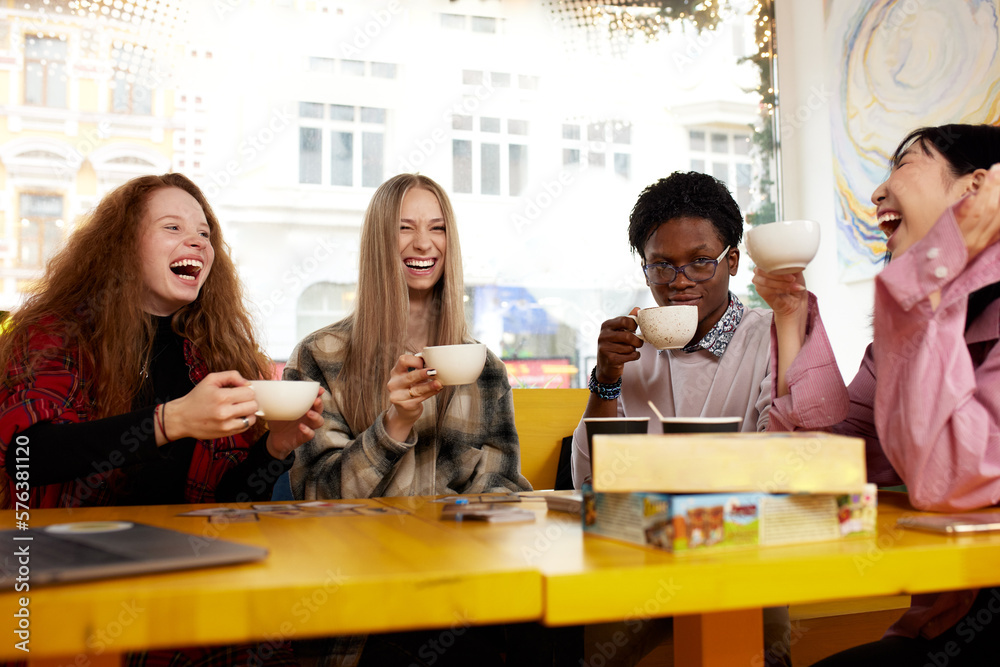 Group of multiracial young people sharing ideas and having friendly conversation during coffee break at business meeting in office, panorama Group of multiracial young people sharing ideas and having friendly conversation during coffee break at business meeting in office, panorama