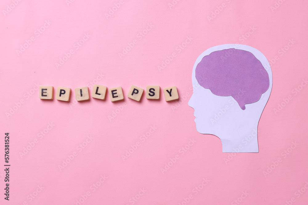 Brain paper cutout with epilepsy lettering on pink background. World epilepsy day. 