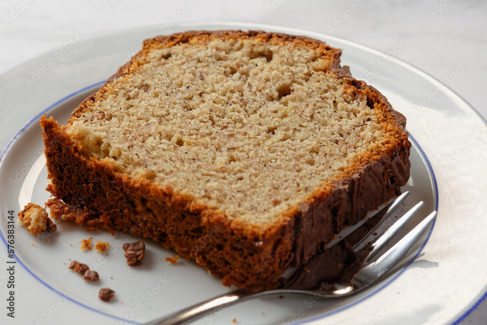 Homemade nut cake with chocolate icing served on a white plate. Homemade nut cake with chocolate icing served on a white plate.