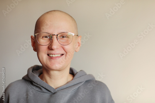 Smiling bald woman in glasses struggle with oncology look at camera. Hairless cancer sick female patient after chemotherapy lost her eyebrows and eyelashes feel optimistic of recovery remission