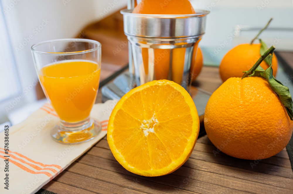 Beautiful close up of a chrome juicer with leafy oranges and juice Beautiful close up of a chrome juicer with leafy oranges and juice