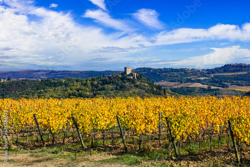 Italy, Toscana scenery . Golden vineyards of Tuscany.  panorama of medieval castle and yellow grapewines. photo