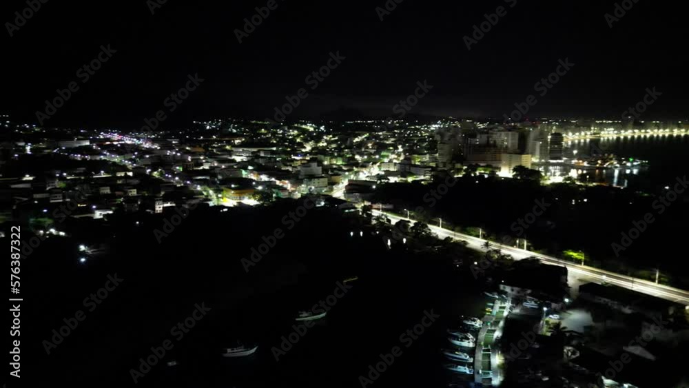 Imagem aérea noturna da cidade de Guarapari no Espírito Santo. Praia do Morro e Centro de Guarapari com luzes noturnas.