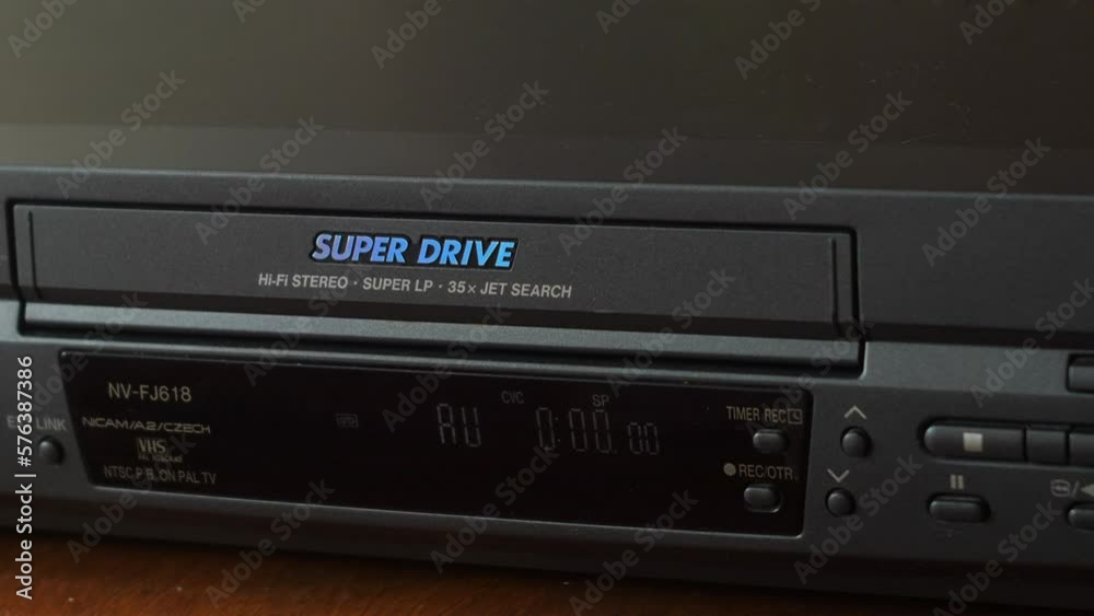 The hand loads the video cassette with a family of a family in a video player. Selective focus. Old archival family videos watch. Nonstalgy, family traditions The hand loads the video cassette with a family of a family in a video player. Selective focus. Old archival family videos watch. Nonstalgy, family traditions