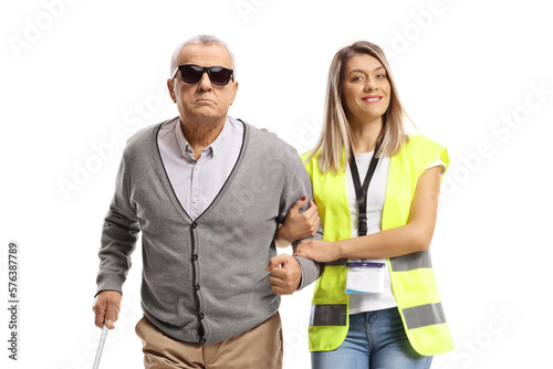 Female community worker helping an elderly blind man