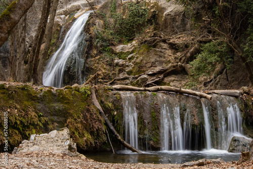 Waterfall in the forest surrounded by trees covered with moss