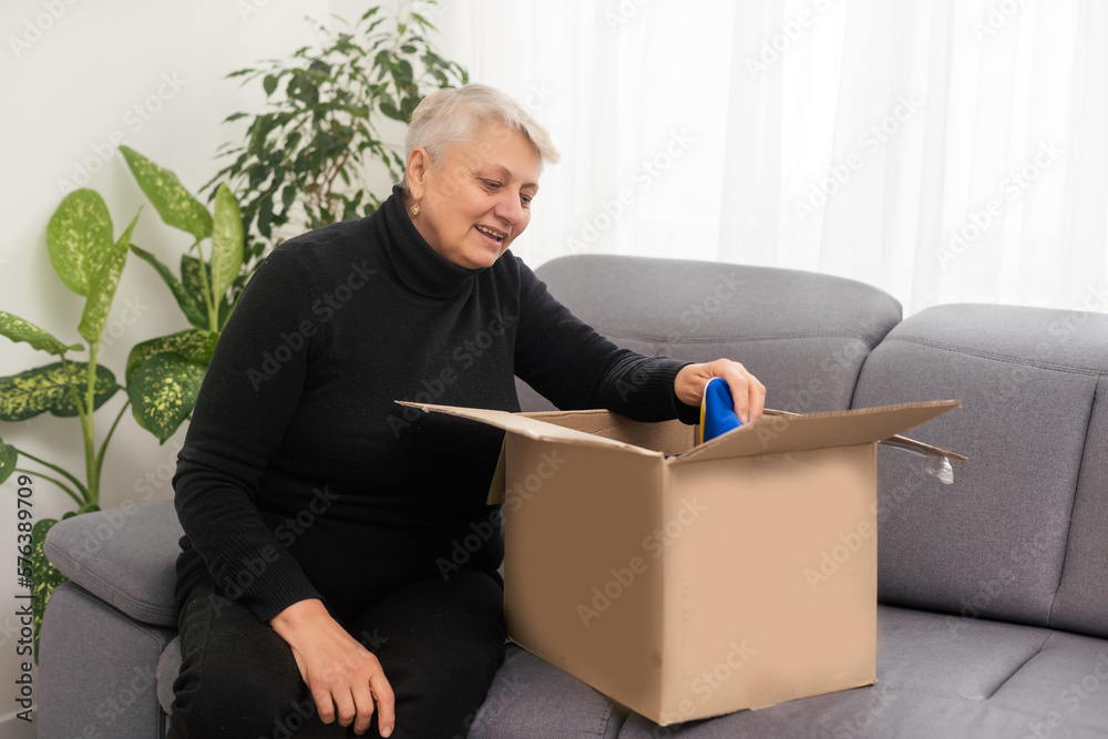 Elderly woman unpacking things in new house. Female hands opening cardboard box. Real estate, purchase, moving concept. Elderly woman unpacking things in new house. Female hands opening cardboard box. Real estate, purchase, moving concept.