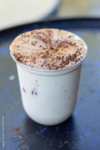 plastic cup of Cavendish Banana fresh milk Whey shake sprinkle with cocoa powder focus view 