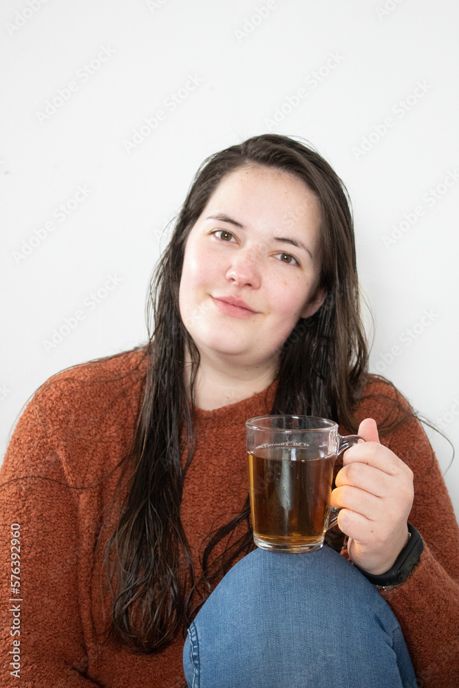 Young woman with wet hair enjoys her cup of tea Young woman with wet hair enjoys her cup of tea