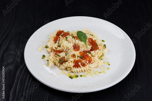 Pasta with red caviar on black background
